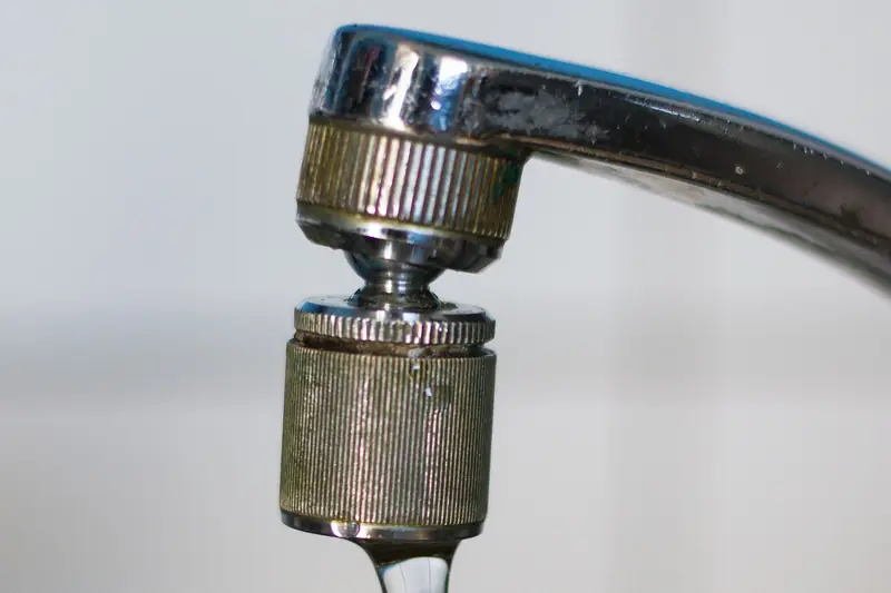 A chrome kitchen tap's aerator, close up