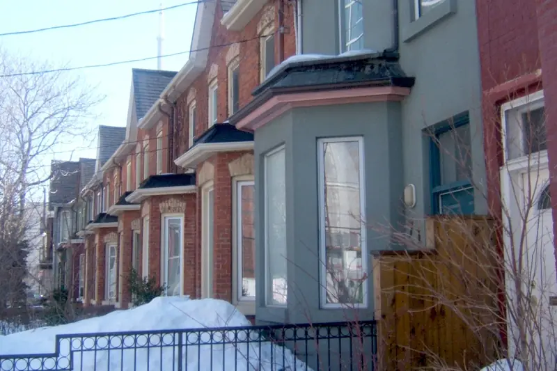 Toronto row houses with bay windows and snow banked along the front walks